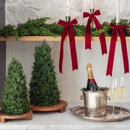 Decorative setup with candles, red ribbons, and a bottle of champagne on a kitchen counter.