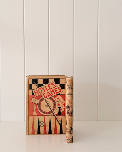 Vintage book titled 'Hoyle's Games' on a white surface with a white paneled wall background